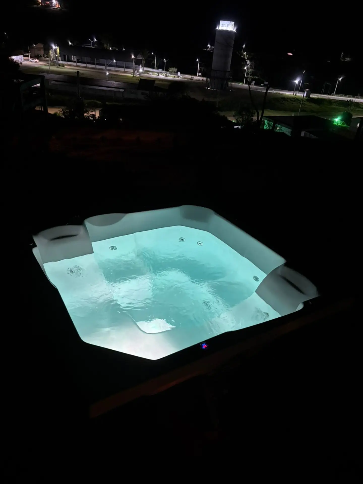 Hidromassagem iluminada durante a noite com vista para o vale